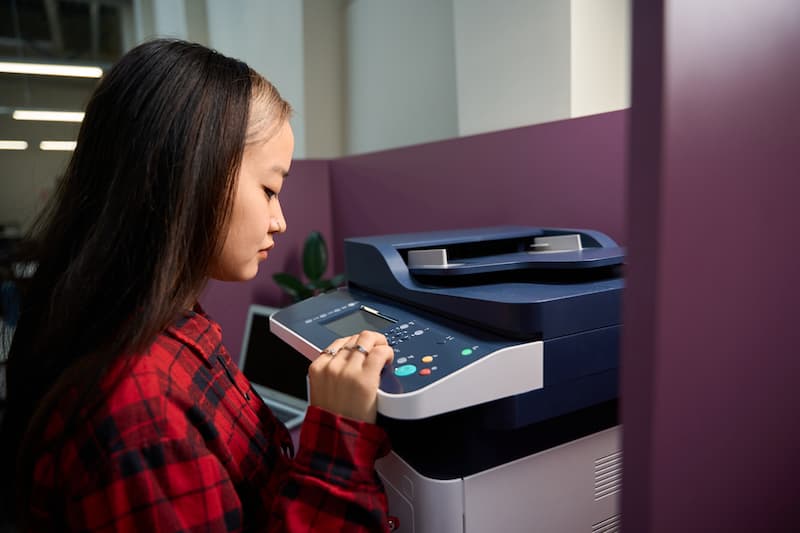 Employee using the control panel of an office copier