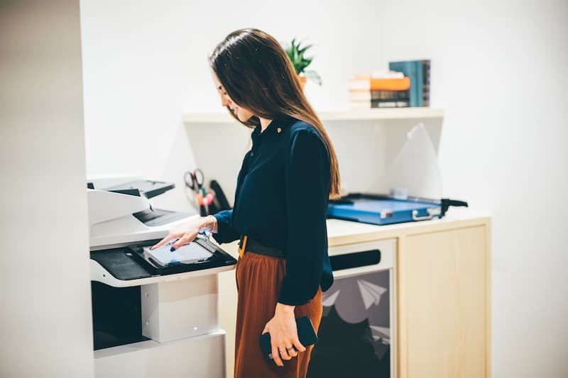 Woman scanning a document on an office copier
