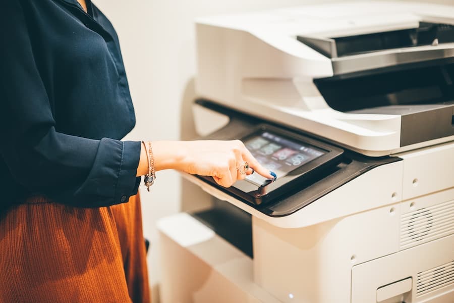 Employee selecting a job on a full-size copier touchscreen