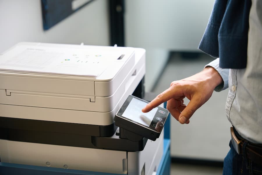Hand selecting an option on a copier touch panel