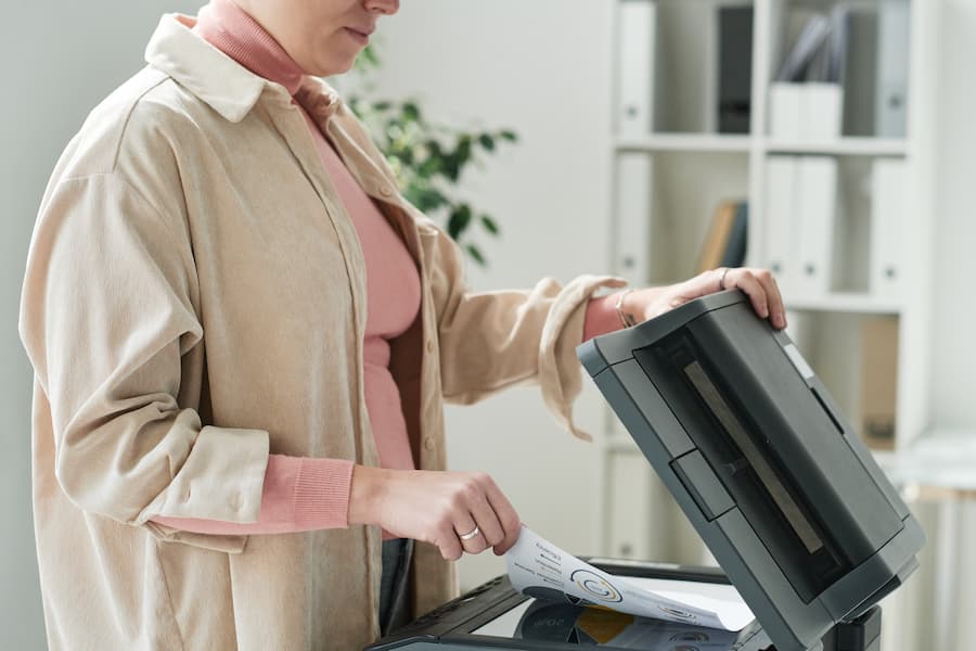 Office worker loading a document into a copier