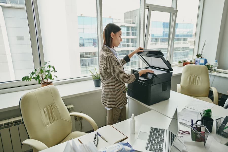 Office worker scanning a document on a copier by the window