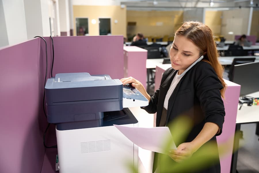 Office worker on a phone call while copying documents