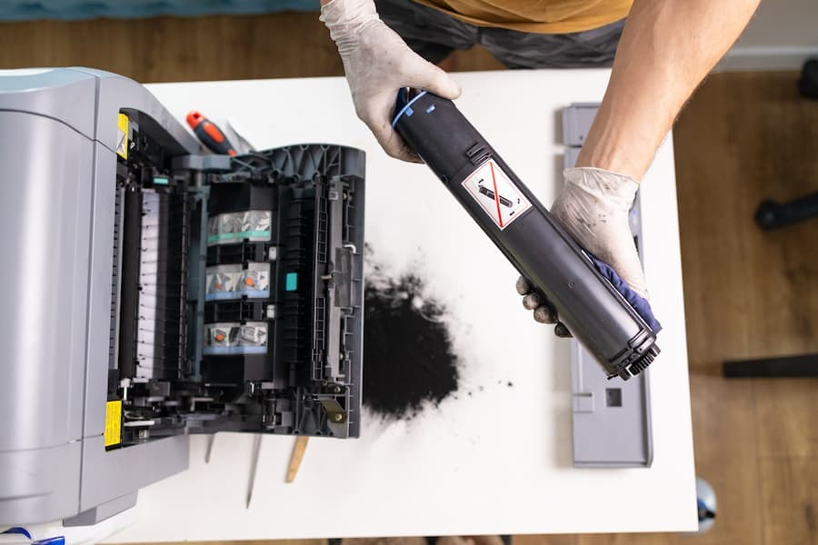 Technician replacing a toner cartridge in an office printer